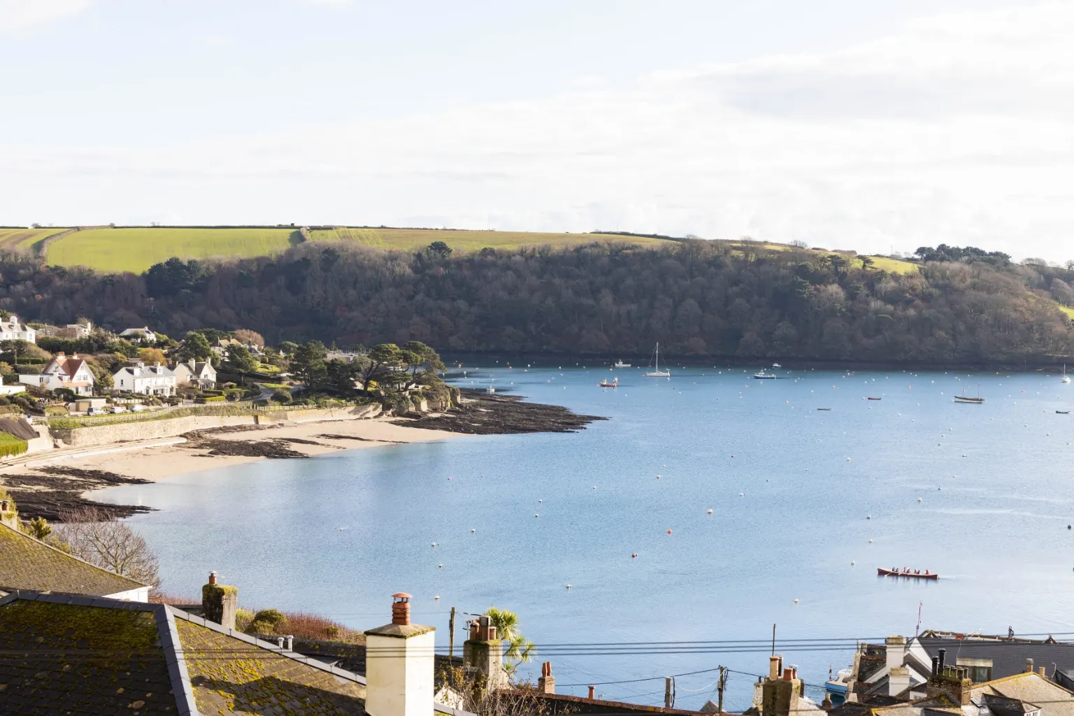View across village rooftops to Summers Beach, the moorings and the wooded far bank