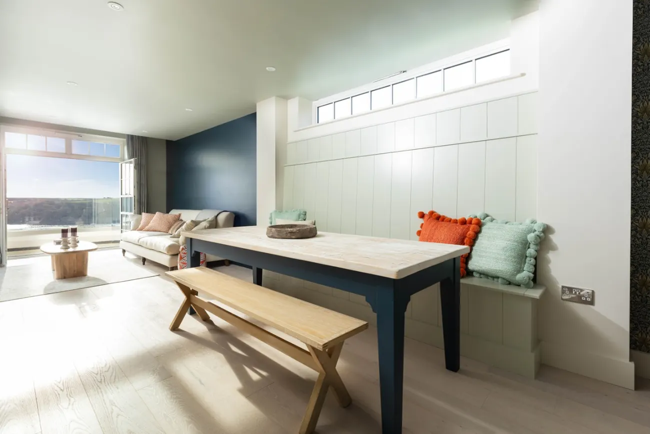 Dining area with a long table, bench seating and a window seat