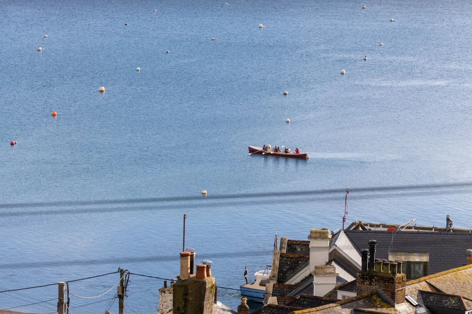 A rowing gig crossing the moorings off St Mawes
