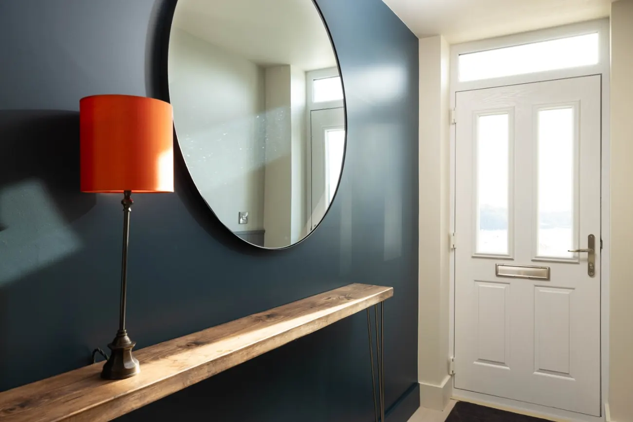 Reception hall with a round mirror over a console table